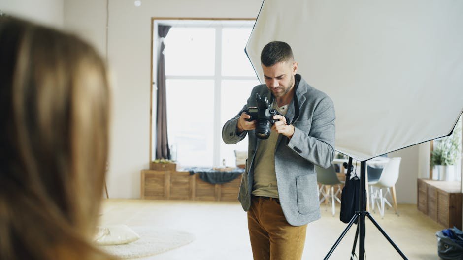 Photographer and stylist setting up a brand photoshoot in a studio with lighting, camera rig, and styled props