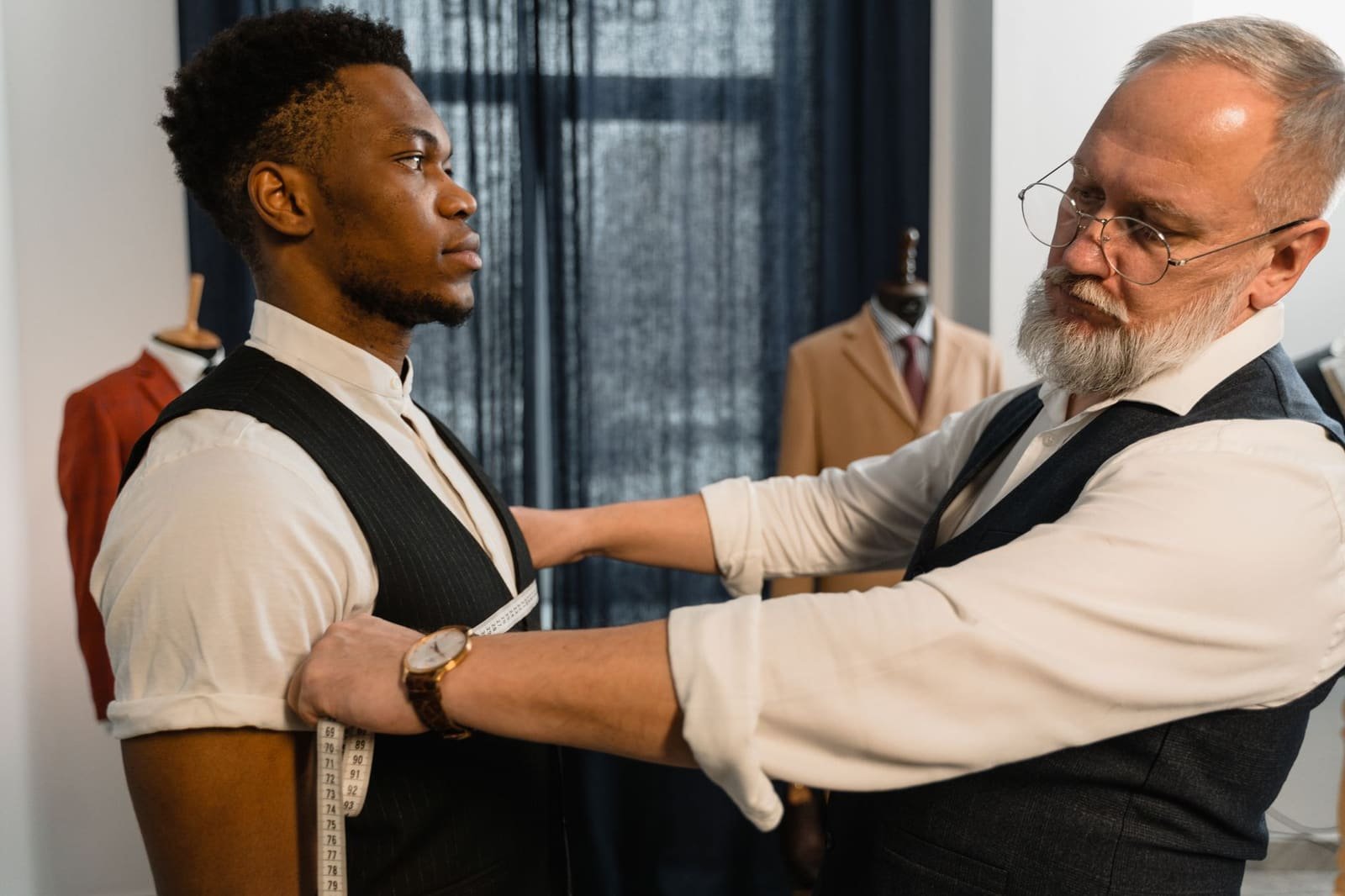 A tailor taking measurements for a bespoke suit in an atelier — the fit-first approach to look for in a Toronto web design agency