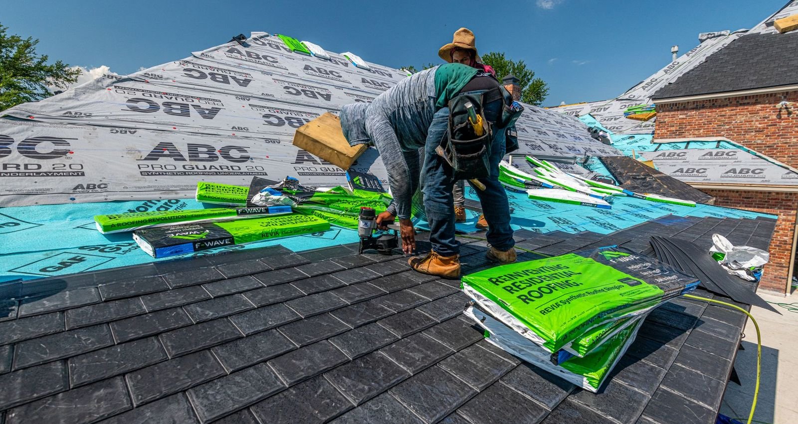 Roofers installing new shingles on a house