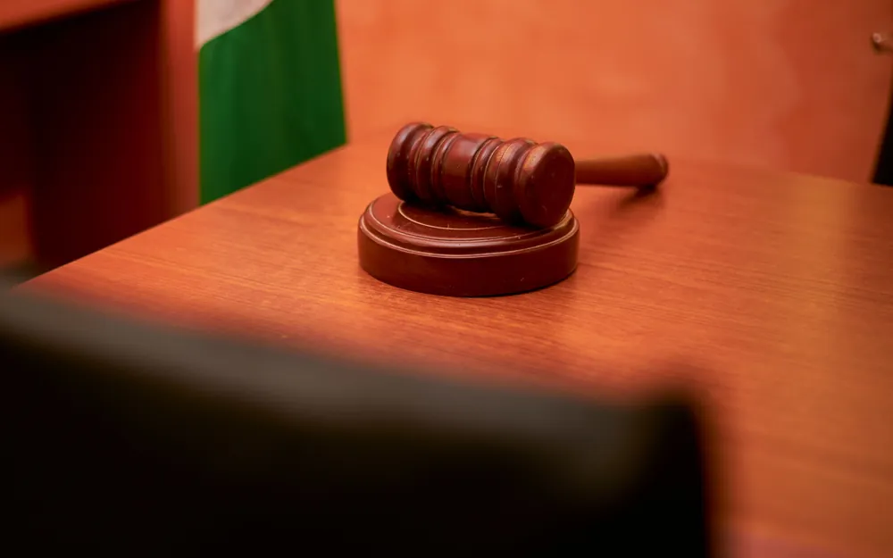 A wooden auction gavel resting on an orange tabletop