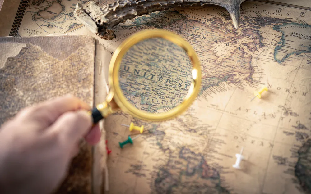 A magnifying glass held over an antique paper map