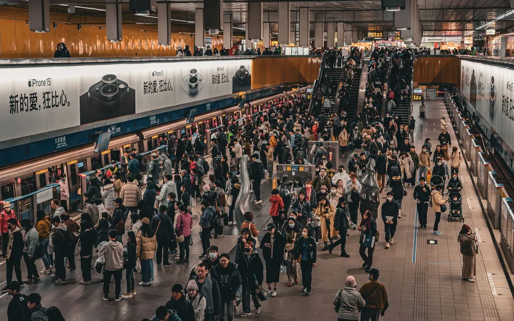 A packed subway platform at rush hour seen from above