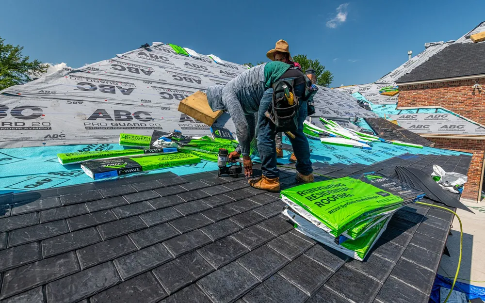 Roofers installing new shingles on a house