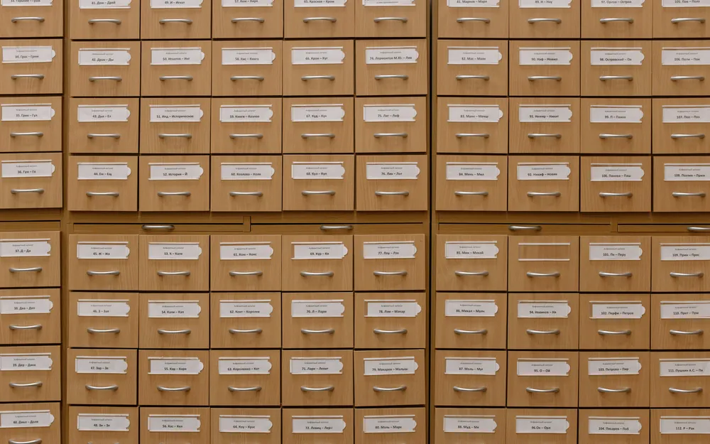 The labelled wooden drawers of a library card catalogue