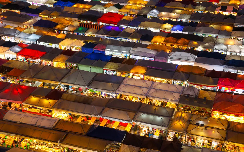 An overhead view of a night market with rows of brightly lit stalls