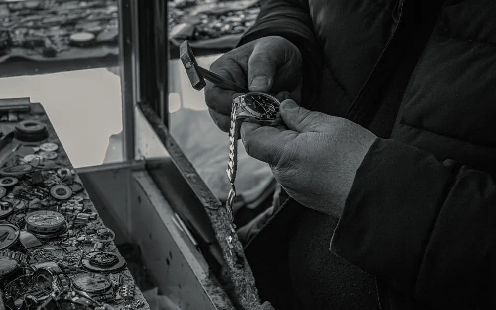 A watchmaker working on a watch movement with fine tools