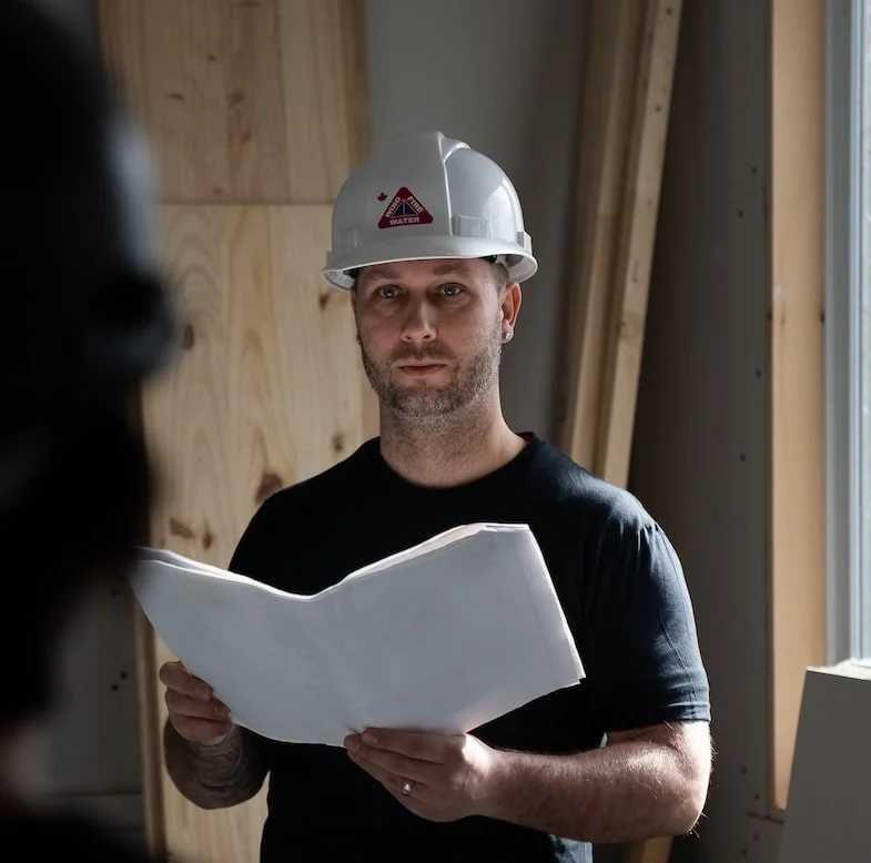 DKI site supervisor reviewing plans — the brand's documented photography style