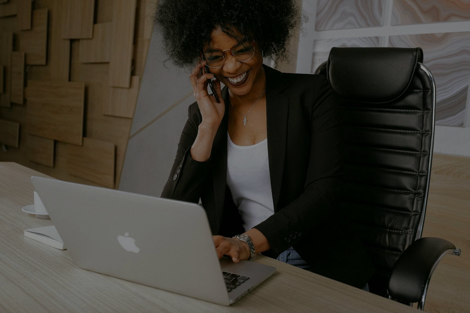 Business owner answering a customer call at her laptop
